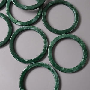 Detailed macro view of dark green marble resin handles with vintage acrylic textures