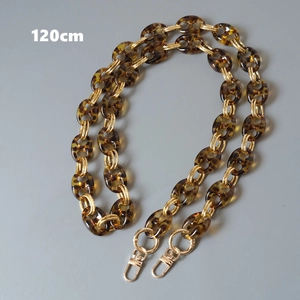 Macro detail of 120cm amber acrylic pig nose chain with gold metal rings for shoulder bags