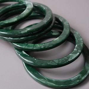Macro shot of dark green resin handles with white marble texture for DIY bags