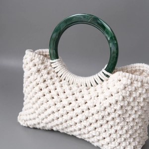 Close-up of macramé bag with white cotton cord and green marble resin handle