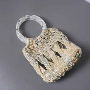 Detail of tricolor woven handbag with marble texture acrylic circular handles