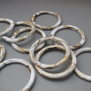 Macro shot of 10cm resin round handles with brown marble pattern for DIY handbags