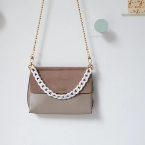 Detail of color-block resin chain on brown suede and taupe leather crossbody bag