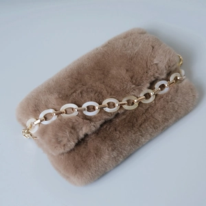 Brown faux fur clutch bag featuring a decorative acrylic resin and gold metal chain link
