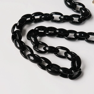 Macro shot of polished black acrylic thick chain strap with glossy mirror finish for handbags