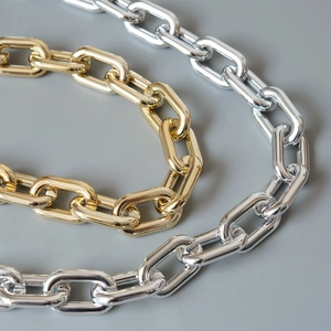 Close-up of chunky gold and silver chain links with polished metallic finish