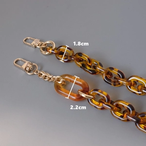 Fashionable amber tortoiseshell acrylic bag chain with gold lobster clasps and metal links