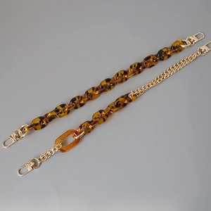 Close-up of amber leopard resin acrylic chains with gold lobster clasps for bags