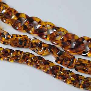 Macro shot of vintage amber acrylic chunky chain links in circular and rectangular shapes