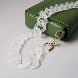 Detail of dark green matte bag featuring a chunky frosted white resin chain strap