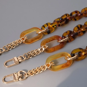 Detailed view of leopard print acrylic links and gold metal chain with lobster clasp
