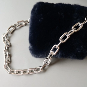 Detailed shot of dark blue faux fur shoulder bag with polished silver metal chain strap