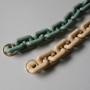 Dettaglio di tracolle per borse in resina verde menta e bianco crema con anelli oro