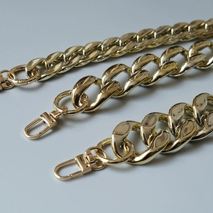 Golden chunky Cuban link bag straps with lobster clasps in polished metallic finish