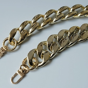 Detail of chunky gold metal chain strap with lobster clasps for handbags