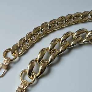 Close-up of golden metal thick chains with lobster clasps for handbags shoulder straps