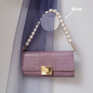 Detail of purple crocodile-patterned handbag with 45cm pearl handle and gold metal lock