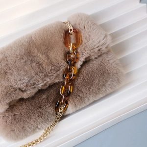 Detail of leopard print faux fur bag with amber acrylic and gold metal chain strap