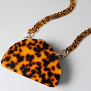 Close-up of leopard tortoise shell acrylic resin evening bag with thick matching chain