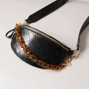 Quilted black leather waist bag featuring a bold tortoiseshell acrylic chunky chain strap
