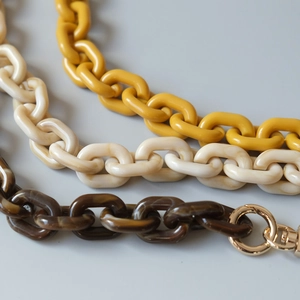 Detail of colorful resin acrylic chains with golden metal buckles in various patterns