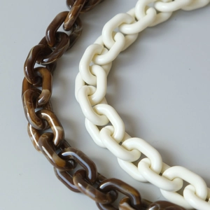 Detailed macro view of tortoiseshell and cream resin chain links for shoulder straps