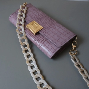 Close-up of purple crocodile pattern PU leather with creamy marble acrylic chain strap