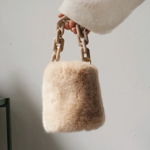 Borsa a secchiello in pelliccia sintetica beige con tracolla a catena in resina