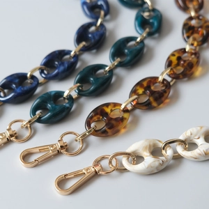 Macro shot of assorted marble resin chain straps with gold lobster clasps for handbags