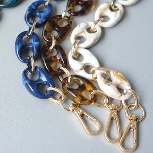 Detailed view of leopard resin bag chains with gold metal links and lobster clasps