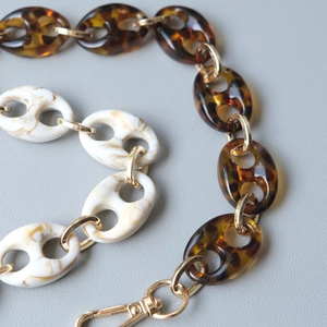 Detailed macro view of resin leopard print chain links with polished gold metal rings