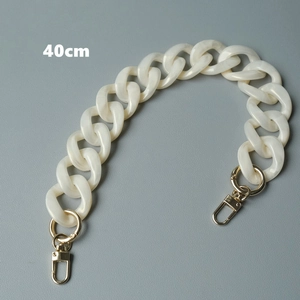 Detalle de cadena para bolso de 40cm en acrílico jaspeado crema con cierres dorados