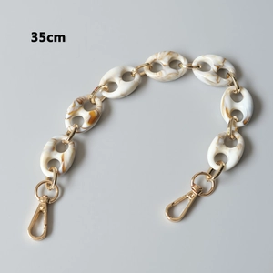 Detail view of a 35cm acrylic resin handbag chain with marble pattern and gold lobster clasps