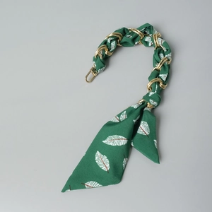 Detail of green silk scarf braided with gold chain for handbag strap replacement