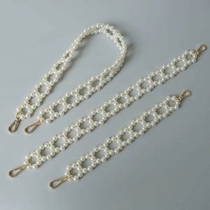 Close-up of three lengths of woven white pearl bag straps with gold lobster clasps for DIY