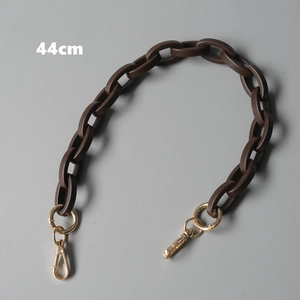 Detail view of a 44cm coffee resin acrylic handbag strap with gold swivel lobster clasps