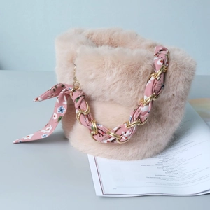 Detail of pink faux fur bucket bag featuring a silk scarf interwoven with a gold chain