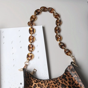 Detail view of leopard print bag with amber acrylic resin chain and metal clasp