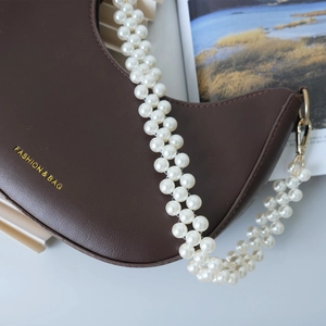 Vue détaillée d'un sac hobo marron avec une élégante bandoulière en double rangée de perles