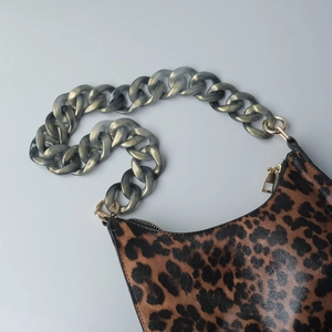 Detalle de la cadena de resina gris y textura de estampado de leopardo del bolso de hombro