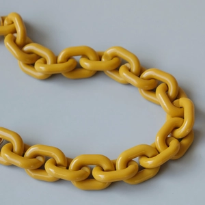 Macro shot of thick ginger yellow resin chain links with a polished glossy finish