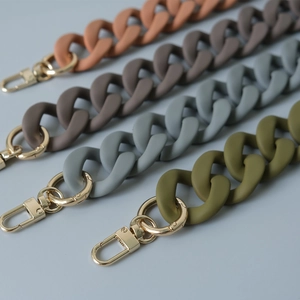 Detail of matte acrylic resin chains for handbags with gold metal lobster clasps