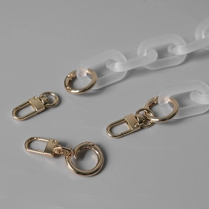 Detail of matte white acrylic resin chain with light gold spring ring clasps and hardware