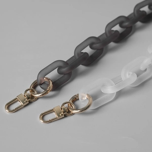 Macro shot of matte white and gray acrylic chain links with gold lobster clasps for bags