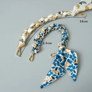 Détail d'un foulard en soie fleurie tissé avec chaîne en métal doré pour sacs à main