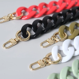 Detailed macro view of acrylic resin bag chains with golden lobster clasps in various colors