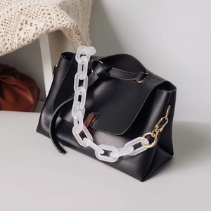 Black leather handbag with a vintage white matte acrylic chain and gold hooks