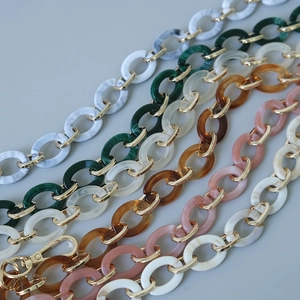 Détail des maillons de chaîne en résine acrylique colorée avec fermoirs mousquetons dorés
