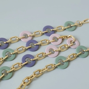 Detail of colorful acrylic resin rings with gold metal chain links and lobster clasps