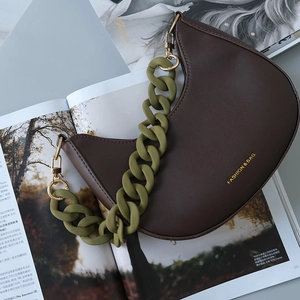 Detail shot of a brown crossbody bag with olive green chunky acrylic chain and gold ring